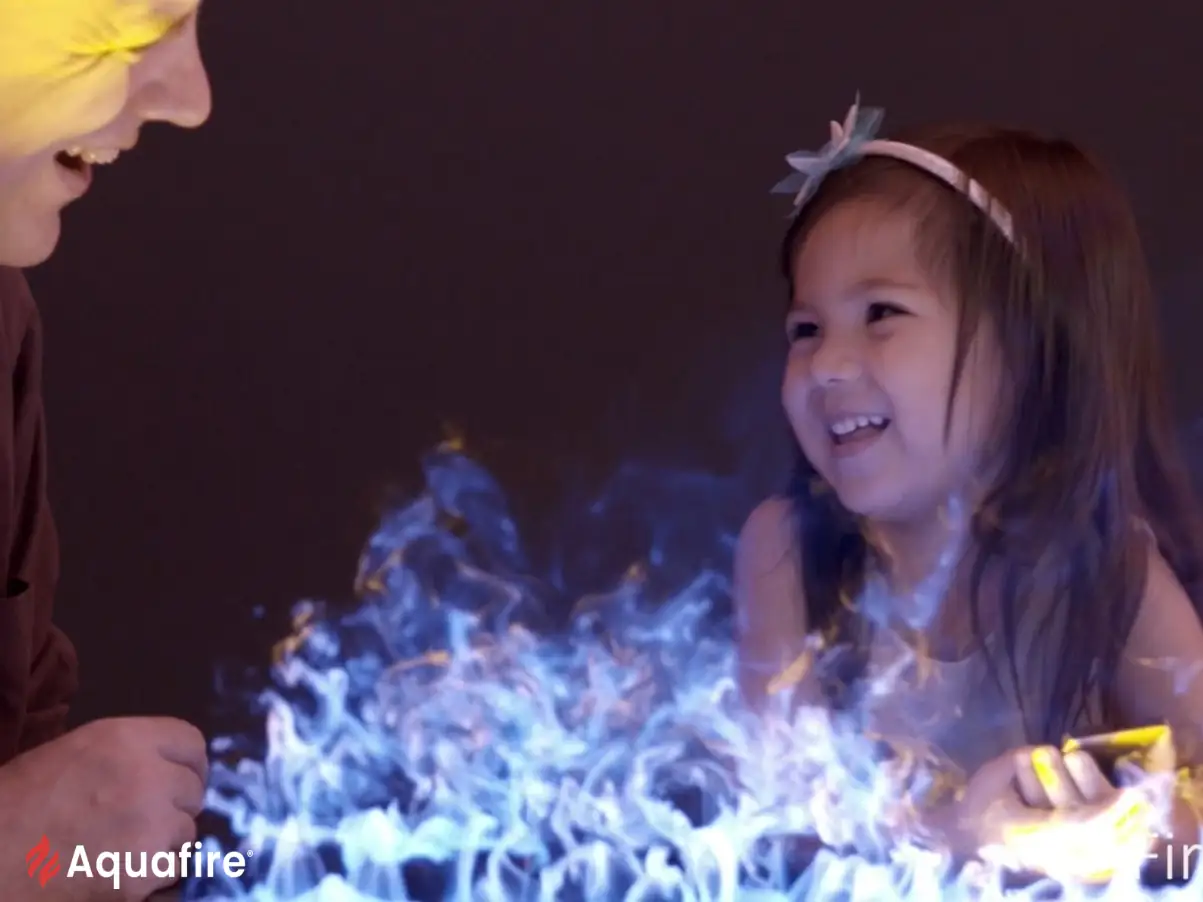 Niño junto a una chimenea de vapor de agua con llamas frías – segura y decorativa